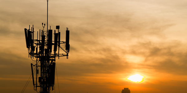 A sunset with a cellular tower in the foreground.
